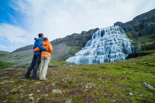 Couple of tourists near Dynjandi is the most famous and beautiful waterfall of the West Fjords in Iceland.