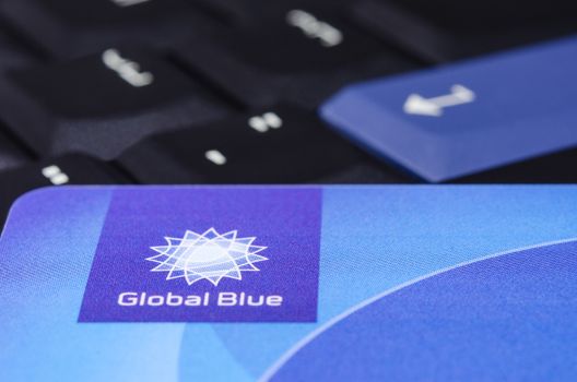 MUNICH, GERMANY - FEBRUAR 20, 2014: Global Blue closeup logo on plastic card against black ThinkPad keyboard.