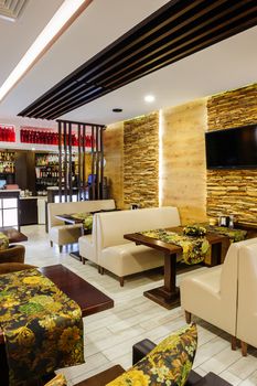 Modern restaurant interior with tables and sofas