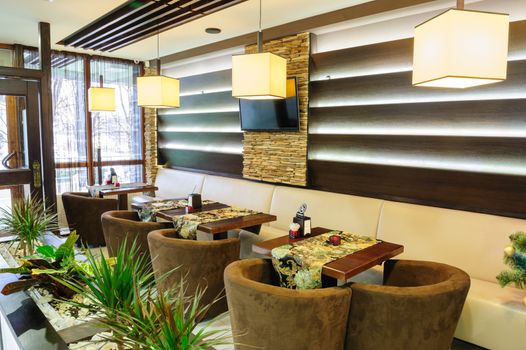 Modern restaurant interior with tables and sofas