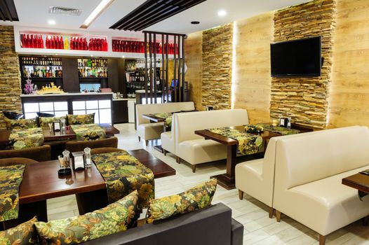 Modern restaurant interior with tables and sofas