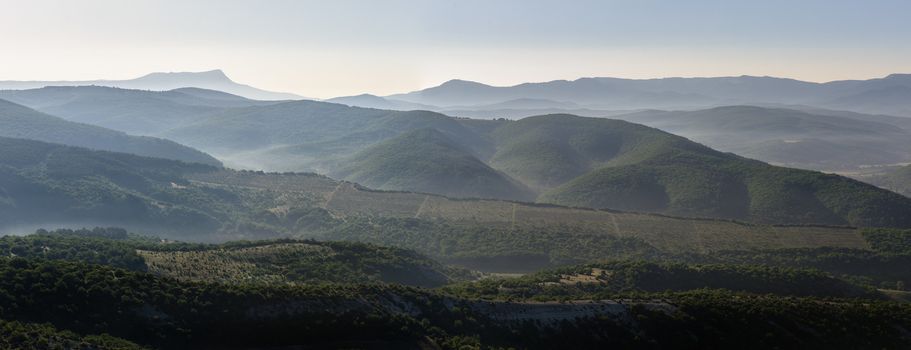 Landscape, sunrise over foggy hills, panorama stitched from 3 frames