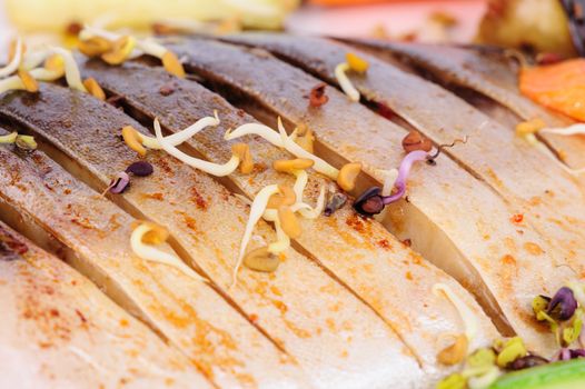 oriental cuisine, sprouted soybeans over fried fish, macro closeup