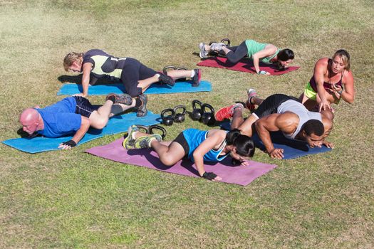 Bootcamp fitness trainer coaching diverse class outdoors