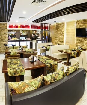 Modern restaurant interior with tables and sofas