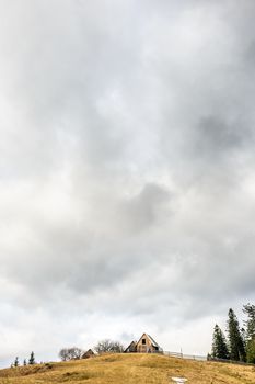 lonely house on the top of hill against the cloudy sky