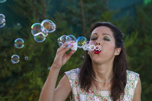 a beautiful woman blowing bubbles. spring season, rural scene