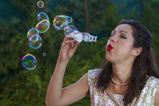 a beautiful woman blowing bubbles. spring season, rural scene