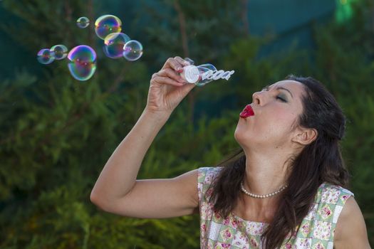 a beautiful woman blowing bubbles. spring season, rural scene