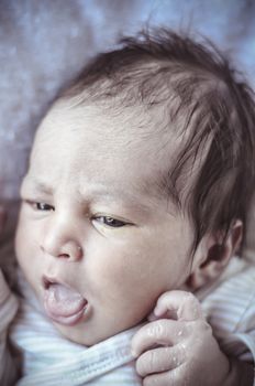 new born baby curled up sleeping on a blanket, multiple expressions