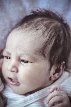 new born baby curled up sleeping on a blanket, multiple expressions