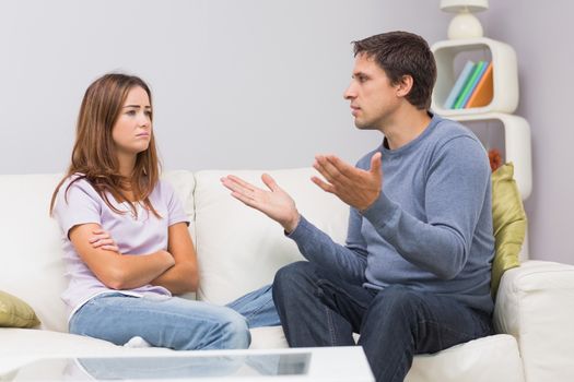 Angry couple having an argument in their living room at home