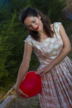 Valentine's Day. Beautiful smiling woman with a gift in the form of heart in his hands