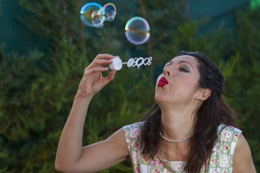 a beautiful woman blowing bubbles. spring season, rural scene