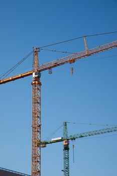 Tower cranes against clear blue sky