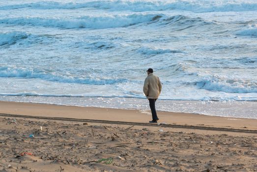 Man Walks Along Coast and see on storm waves