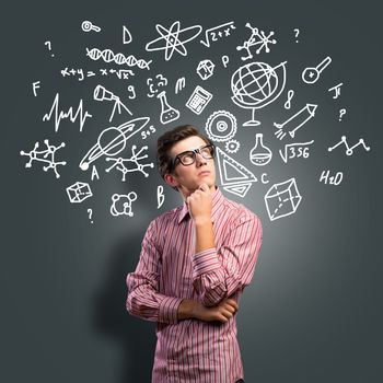 young man scientist in glasses thinking. next to it various painted symbols