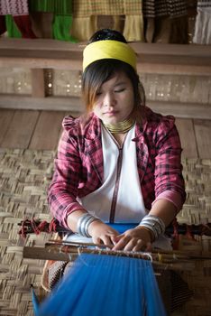 INLE LAKE, MYANMAR (BURMA) - 07 JAN 2014: Unidentified Padaung (Kayan Lahwi) tribe woman weave on traditional device. This tribe is called "long neck"���� because of metal rings around their necks.