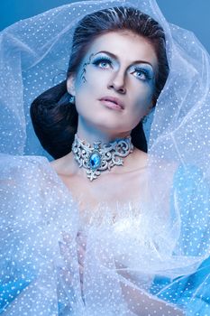 Attractive girl with scenic makeup in the image snow queen