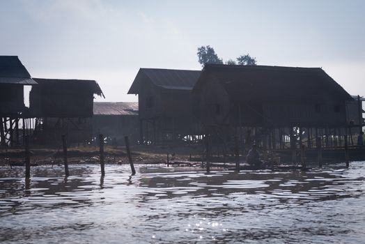 NYAUNG SHWE, INLE LAKE, MYANMAR (Burma) - 07 JAN 2014: Traditional stilts wooden and bamboo house of Intha people in water on Inle lake, Myanmar (Burma) 