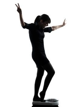one woman standing on weight scale happy silhouette studio isolated on white background