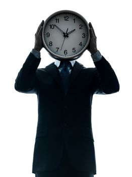 one caucasian businessman holding clock in silhouette studio isolated on white background