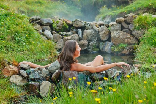 Beautiful young woman in wild geothermal spring, Iceland