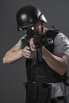 Safety, paintball sport player wearing protective helmet aiming pistol ,black armor and machine gun