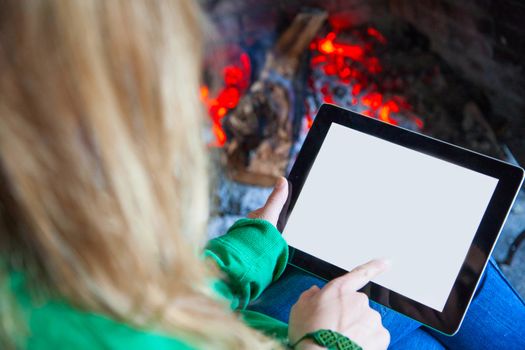 Woman with a tablet fire place and reading