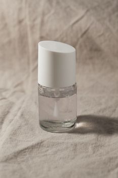 A transparent Nail polish over beige background