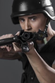 Gunfire, paintball sport player wearing protective helmet aiming pistol ,black armor and machine gun