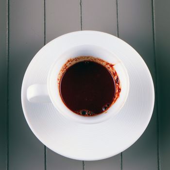 Hot Chocolate in small white cup, over wooden background