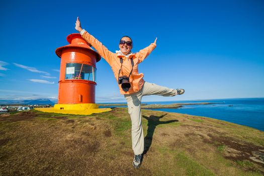 Woman having fun near Red lighthouse in Stykkisholmur, Iceland on the Snaefellsnes peninsula.