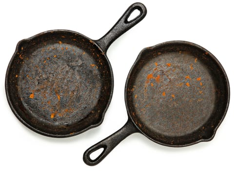 Set of Two Rusty Cast Iron Skillets over white.