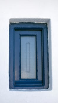 Blue small window closeup in a old white house