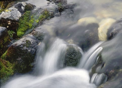 waterfall over rocks in mountain