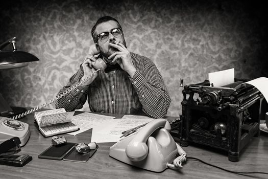 Man smoking a cigarette while talking on the phone, 1960's scene