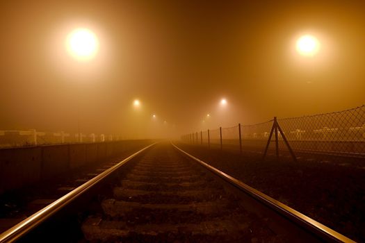 Rails in the fog at night