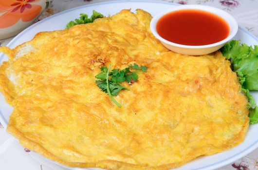 fried beaten egg with parsley on top - Thai cuisine omelet