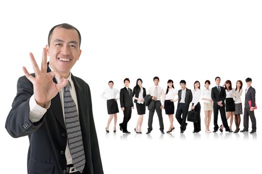 Mature businessman give you a gesture of okay and standing in front of his team on studio white background.