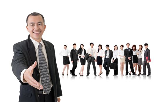 Confident businessman shake hand with you and standing in front of his team on studio white background.
