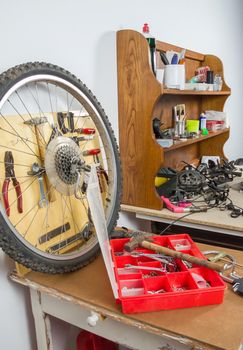 Wheels and bicycle parts over workshop table in the restoration process of a damaged bike