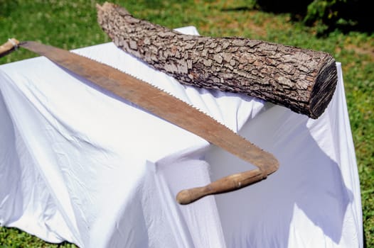 Hand saw and tree trunk on a table