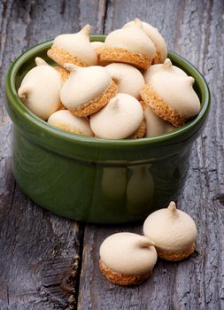 Delicious Swirled Meringue Topping in Green Bowl isolated on Rustic Wooden background