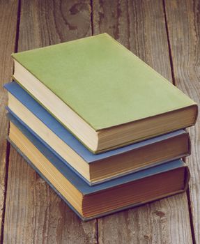 Stack of Three Old Books isolated on Rustic Wooden background. Retro Styled
