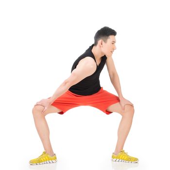 Asian sport young man doing warming-up exercises, full length portrait isolated on white background.