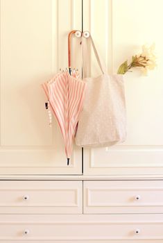 Umbrella and tote bag hanging on vintage wardrobe with retro filter effect