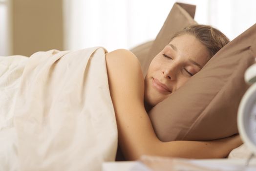 Young beautiful woman sleeping comfortably on bed