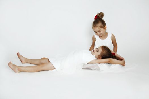 Young girls in the studio. White dresses.
