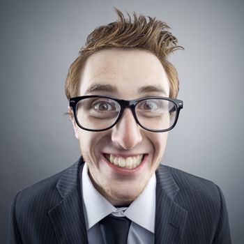 Portrait of young cheerful Nerd businessman smiling